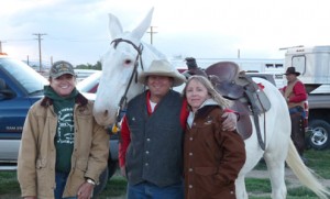 Bryce Hathaway, flanked by two women, poses with his snow white mule White Trash.