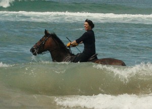 Broekman beams as she canters through the New Zealand surf on her bay Station Bred horse.