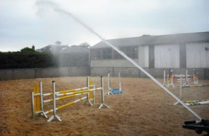 A sprinker system that sprays water over large areas, such as this, is necessary for dust control in riding arenas.