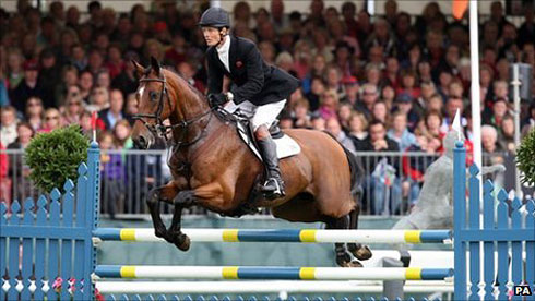 Eventer William Fox-Pitt, caught mid-air over a jump, rides his bay horse to a record 6th victory.