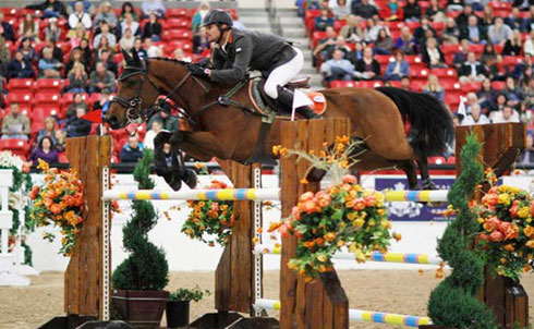 Eduardo Menezes sails over a vertical jump on his horse Calavda before a full house in Las Vegas.