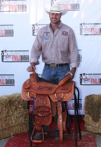 Steer wrestler Ethen Thouvenell poses with his hand-tooled Corriente trophy saddle.