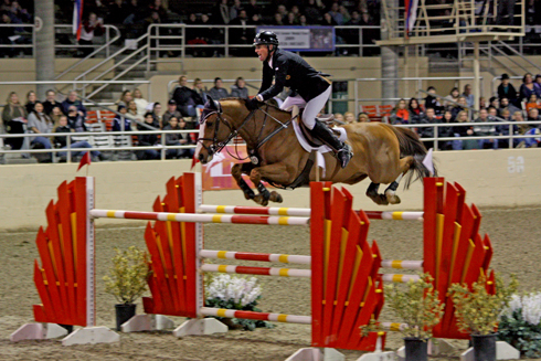 Rich Fellers and his fiery chestnut horse Flexible fly over an orange jump.