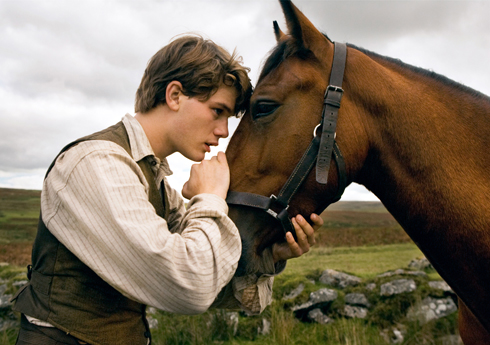 Albert (Jeremy Irvine) rests his head contemplatively against that of his horse Joey in Steven Spielberg's War Horse.