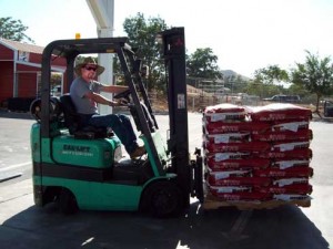 Man on a forklift loaded with animal feed.