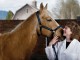 A veterinarian poses with a horse.
