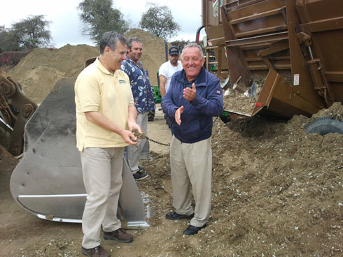 George Chatigny and Rudy Leone stand before a huge pile of arena footing.