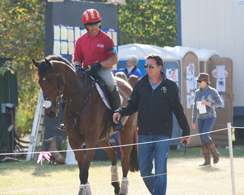 Robert Kellerhouse walks with rider Buck Davidson (astride horse).