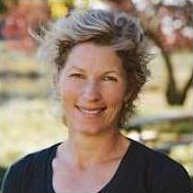 Portrait of Simone Coxe, standing in an autumn field.