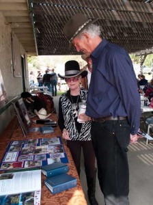 Bari Bonnett in front of a memorial of her husband's photos, attire and artifacts.