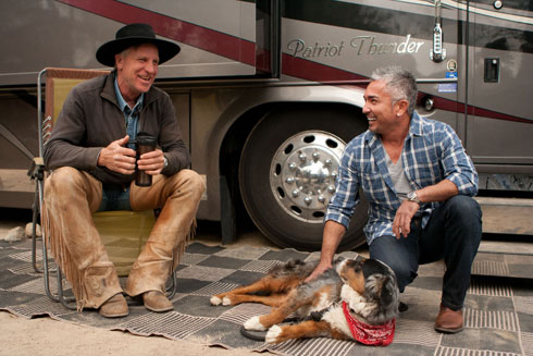 Buck Brannaman, Cesar Milan and a dog sit outside Brannaman's tour bus.