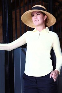 Woman in a long-sleeved white shirt and straw hat.