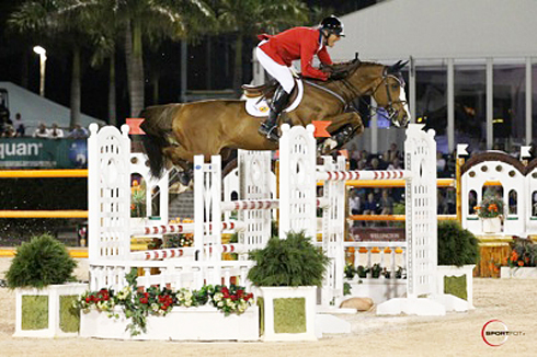 Rich Fellers in a red jacket clearing a huge white oxer on Flexible.