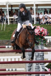 Saer Coultr and her bay horse clear a red vertical jump.