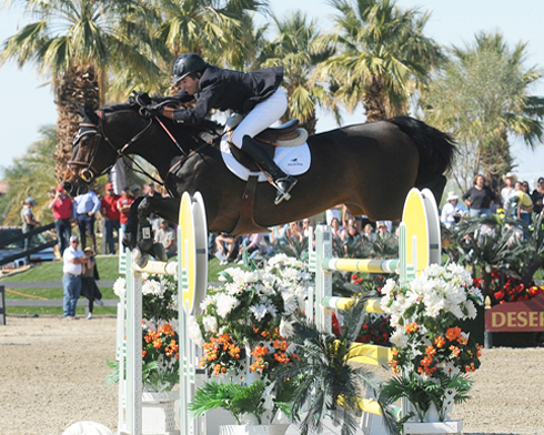 Chris Pratt and his bay horse Cruise sail over a yellow oxer jump.