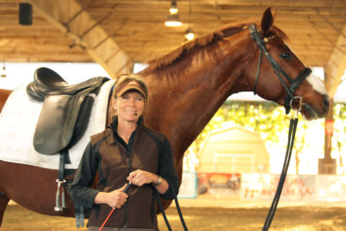 Trainer Linda Parelli standing in front of a horse.