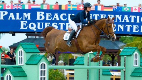 Reed Kessler and Cylana jump a bright green oxer built on a "house" motif.