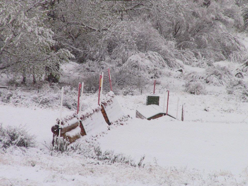 A cross country eventing jump buried in snow.