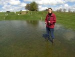 Woman standing in a flooded field at Badminton