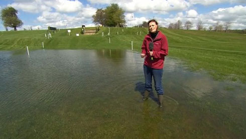 Woman standing in a flooded field at Badminton