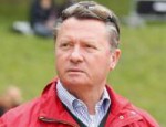 Headshot of Holger Schmezer looking dapper in a red jacket.