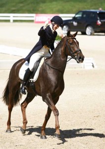 Allison Springer gives a victory pump with her fist after a successful dressage ride.