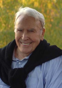 John Quirk smiling in a grassy field