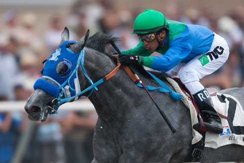 Grey Thoroughbred Creative Cause and jockey Raphael Bejarno look striking racing in bright blue and green silks.