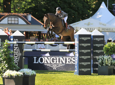 Meredith Michaels-Beerbaum and Bella Donna 66 clear the Longines oxer on the grass in Wiesbaden.