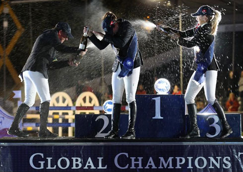 Trio of winners spray each other with champagne in Switerland.