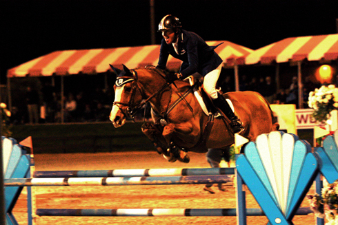 Rich Fellers and Flexible clear a jump on a night course. 