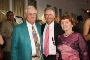 A beaming Will Simpson is flanked by his colorful parents.