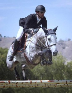 Eduardo Menezes soars over a jump on his graceful grey mare.