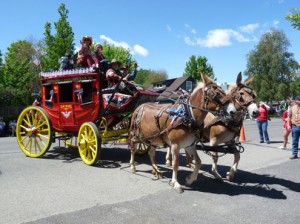 Bright red vintage "mail wagon" pulled by a pair of heavy breed mules