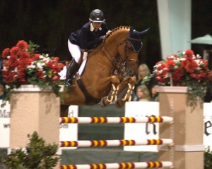 Kristen Coe and her chestnut horse clear a huge jump.