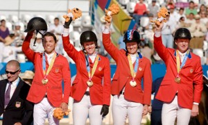 The US Team shines in their nation's red coats as they stand on the podium to receive their gold medals.