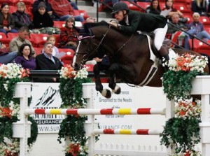 Karl Cook pilots his horse JonKheer leap a vertical jump in Las Vegas.