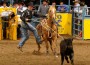 Trevor Brazile hops off his horse while roping a calf.