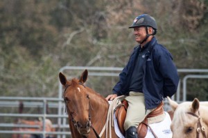 Will Simpson in an English jumping saddle astride his chestnut mare.