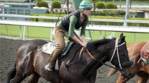 Close-up of Kerry Condon riding a Thoroughbred race horse.