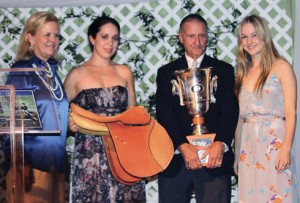 A saddle and silver trophy are presented to young rider Lucy Davis.