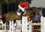 Rich Fellers in a red jacket and his horse Flexible clear a huge white oxer.