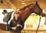 Trainer Linda Parelli standing in front of a horse.