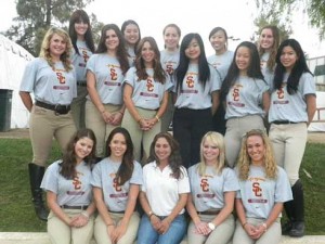 The USC Equestrian Team poses in their team T-shirts with their coach.