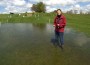 Woman standing in a flooded field at Badminton