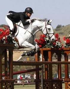 Michelle Paker and her gray mare fly over a jump.