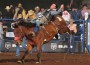 Tyson Thompson lies prone on the bare back of a bucking bronc.