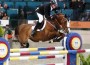 Rich Fellers and Flexible soar over an appropriately themed "championship ribbon" jump