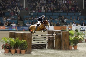 Rich Fellers and Flexible soar over a giant oxer constructed of logs.