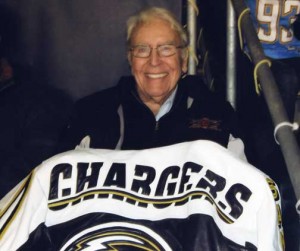 John Quirk holding a Chargers jersey.